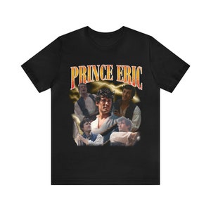 Puede incluir: Camiseta negra con un diseño retro que presenta el texto "PRINCE ERIC" y un collage de imágenes de un hombre. El diseño incluye gráficos de rayos y una estética vintage.