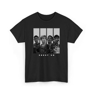 以下が含まれることがあります： 黒の半袖Tシャツで、中央に同じ人物のモノクロポートレートパネル4枚のグラフィックプリントが施されています。パネルの下には、胸の中央に清潔感のある白いサンセリフフォントで「RODDY HO」というテキストがプリントされています。