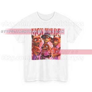 Puede incluir: Camiseta blanca con un gr&aacute;fico de varios zorros de dibujos animados y el texto "NICK WILDE" en un rect&aacute;ngulo rosa. Los zorros est&aacute;n en varias poses y visten camisas moradas. El nombre de la tienda Etsy es visible.
