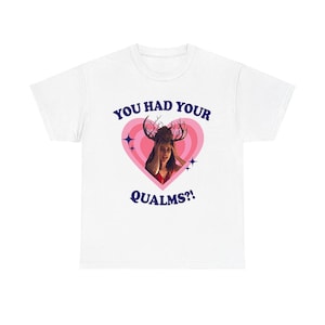 Puede incluir: Una camiseta blanca con un gráfico central de una persona con ramas de árbol en la cabeza dentro de un corazón rosa. El texto "YOU HAD YOUR QUALMS?!" está impreso en letras azul oscuro encima y debajo del corazón, con pequeñas estrellas.