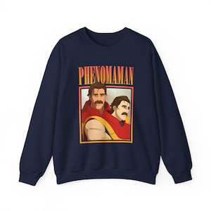 May include: Navy blue sweatshirt featuring a graphic of two men with mustaches in red and yellow attire, with the word "PHENOMAMAN" in orange text above. The design is framed in a yellow border.
