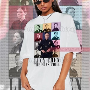 May include: A white t-shirt with a colorful collage of images of a woman in a police uniform. The text "Lucy Chen The Eras Tour" is printed below the collage.