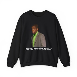 May include: Black sweatshirt with a white graphic of a man in a green shirt and suit jacket. The text "Did you hear about Pluto?" is printed below the image.