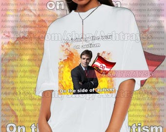 May include: White t-shirt with a graphic of a person in a suit holding a flag with the infinity symbol and the word "autism". The text "Im joining the war on autism" and "On the side of autism" are printed on the shirt.