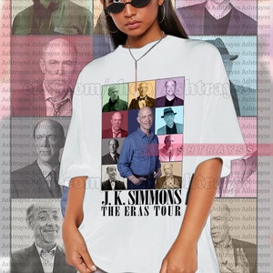 May include: White unisex t-shirt with a grid of J.K. Simmons images and the text "J.K. SIMMONS THE ERAS TOUR". The model is wearing a 2XL shirt. The shirt is designed to be oversized.