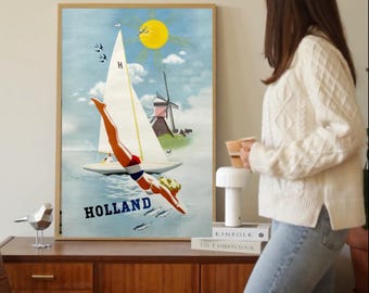 Może przedstawiać: Oprawiony plakat podróżniczy w stylu vintage ze słowem "HOLLAND" na dole. Plakat przedstawia żaglówkę, wiatrak i osobę nurkującą w wodzie. Słońce jest żółte, a niebo niebieskie.