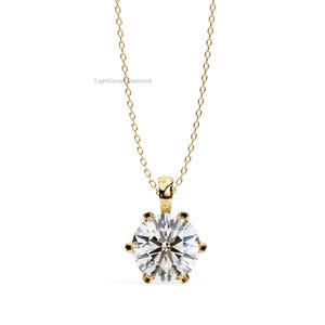 May include: A gold-colored necklace with a large, round, clear gemstone pendant. The pendant is held in place by six prongs. The chain is delicate and also gold-colored. The text "LightGrownDiamond" is visible in the image.