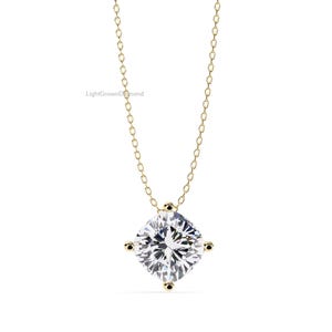 May include: A gold chain necklace with a large, square-cut, clear gemstone pendant. The pendant is held in place by four small gold prongs. The necklace is displayed against a white background. The text "LightGrownDiamond" is visible.
