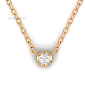 May include: A gold necklace with a hexagonal pendant featuring a clear, round-cut diamond. The chain is made of small, linked gold pieces. The necklace is displayed against a white background. The text "LightGrownDiamond" is visible on the upper left.