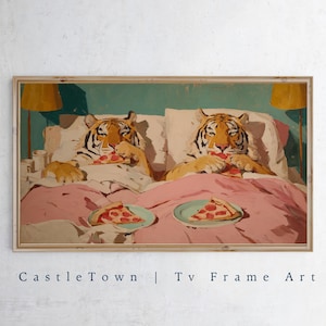 May include: Framed artwork featuring two tigers in bed, eating pizza. The tigers are in a cozy setting with pink bedding, white pillows, and a teal background. The artwork is labeled "Castle Town | Tv Frame Art".