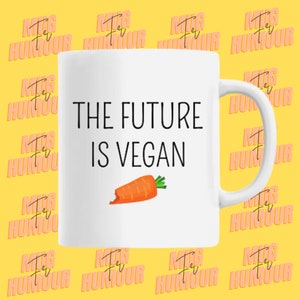 Może przedstawiać: Biały ceramiczny kubek z czarnym napisem "THE FUTURE IS VEGAN", z ilustracją marchewki. Kubek ma zakrzywiony uchwyt i jest umieszczony na żółtym tle.