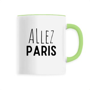 May include: White ceramic mug with a green handle and rim. The mug features the words "ALLEZ PARIS" in black, a phrase associated with Paris, France. The mug is designed for beverages.