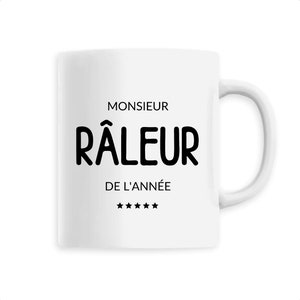Può includere: Tazza in ceramica bianca con manico curvo. La tazza presenta il testo nero "MONSIEUR RÂLEUR DE L'ANNÉE", con cinque stelle nere sotto. Ideale per bevande calde.
