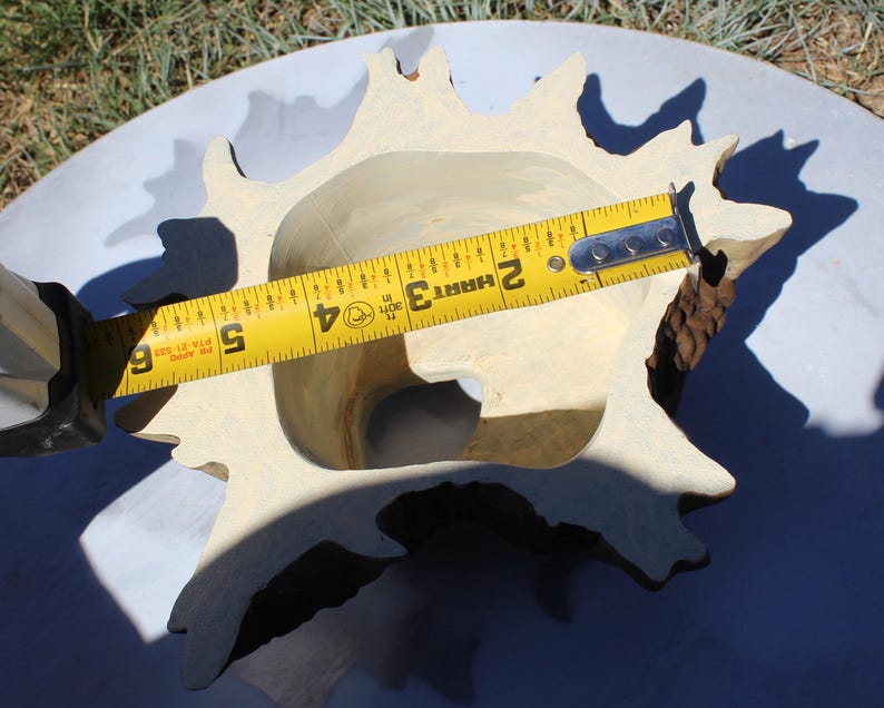 May include: A light-colored, star-shaped decorative bowl with a textured exterior. A yellow measuring tape shows the bowl is approximately 6 inches wide. The bowl has a natural, organic design.