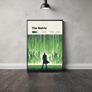 May include: A minimalist poster with a black frame featuring a green and black colour scheme. The poster depicts a silhouette of a person standing in front of a green digital rain background. The text "The Matrix" is displayed in a bold, sans-serif font at the top of the poster.