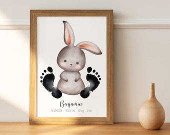 May include: A framed print with a watercolor illustration of a gray bunny with black footprints around it. The print includes the name "Benjamin", the date "16.07.2004", the time "10:25 Uhr", the weight "3210g", and the length "51cm".