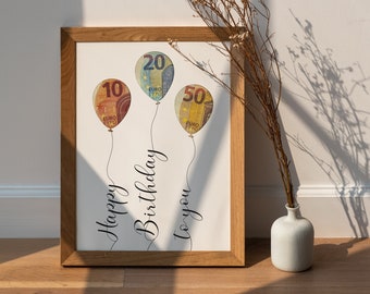 May include: A framed print with a white background featuring three balloons made of euro banknotes. The balloons are labeled with the denominations 10, 20, and 50. The text "Happy Birthday to you" is written in cursive below the balloons.