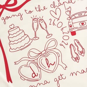 May include: Cream-colored fabric with a red line drawing of wedding-themed elements. Includes a tiered cake, champagne glasses, a car, shoes, hearts, and the text "going to the chapel" and "gonna get married".