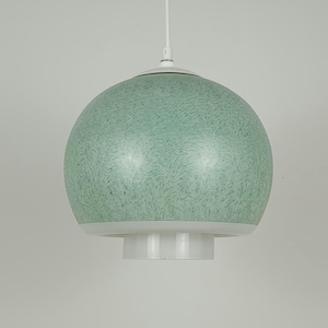 May include: A spherical pendant light fixture with a speckled, seafoam green glass shade. The shade is paired with a white, cylindrical base and a white ceiling mount. The light hangs from a thin white cord.
