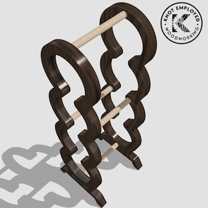 May include: A dark brown wooden towel rack with three tiers and a decorative design. The rack has a rustic look and is made of solid wood.