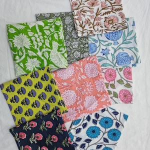 Może przedstawiać: Kolekcja kolorowych, wzorzystych kwadratów materiału. Wzory obejmują nadruki kwiatowe i botaniczne w odcieniach zieleni, różu, błękitu, żółci i granatu. Tkaniny ułożone są na białej powierzchni.