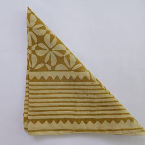 以下が含まれることがあります： 白い花柄とストライプの縁取りが施された黄色の綿の bandana