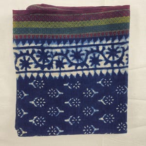 Könnte beinhalten: Ein blauer Baumwollstoff mit einem weißen Blumenmuster und einem burgunderfarbenen, grünen und blauen Rand.