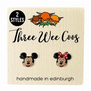 May include: A cream-coloured card displays two pairs of character earrings. One pair is Mickey Mouse, the other is Minnie Mouse with a red polka dot bow. The card has the text "Three Wee Coos" and "handmade in edinburgh".