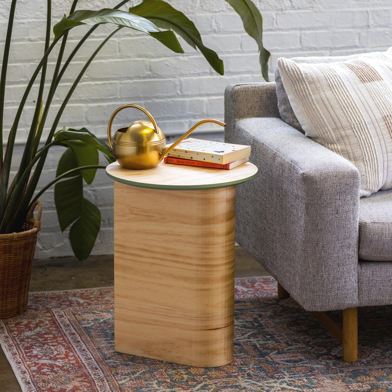 Colorful round top end table in Mid Century Modern style. Photographed in living room setting as side table for couch.
