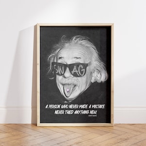 May include: Framed black and white print of Albert Einstein with sunglasses that say "SWAG". His tongue is out. The print has the quote, "A PERSON WHO NEVER MADE A MISTAKE NEVER TRIED ANYTHING NEW." The frame is light brown.