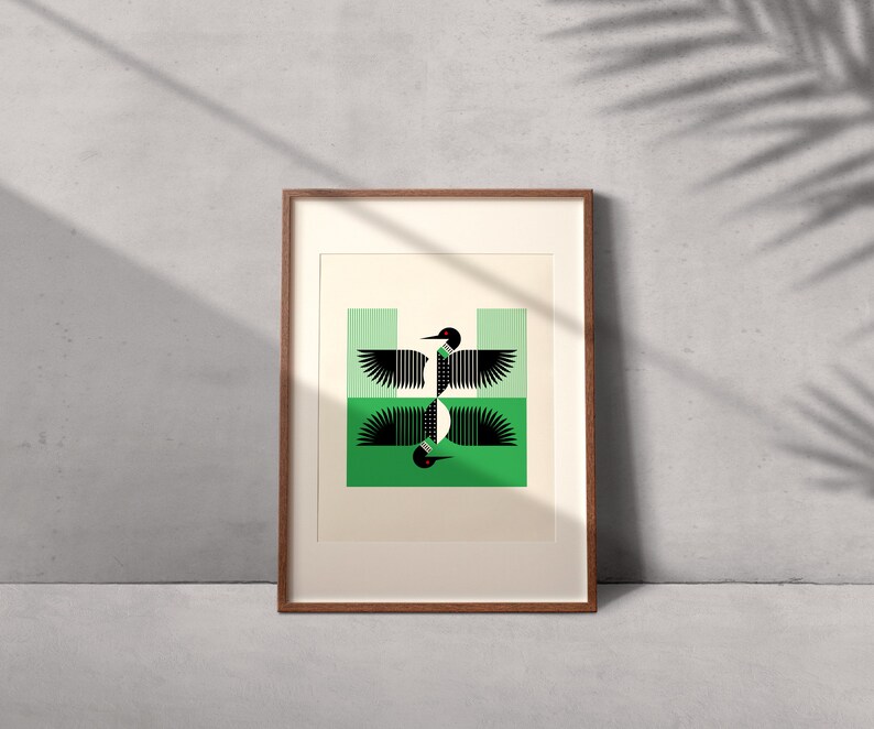 Peut inclure: Une impression encadr&eacute;e d'un motif g&eacute;om&eacute;trique repr&eacute;sentant un huard noir et blanc aux yeux rouges sur fond vert.