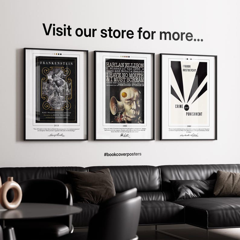 three framed posters on a wall, with a black leather couch and a coffee table in the foreground.