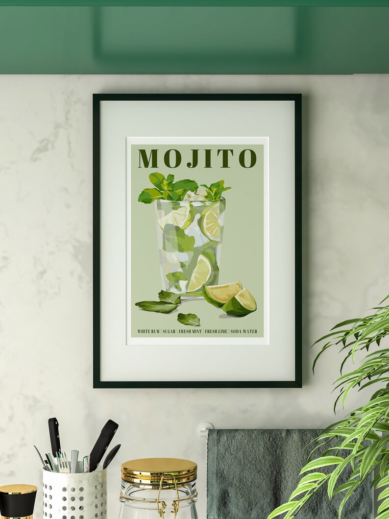 May include: A framed print with a green background featuring a glass of mojito with lime wedges and mint leaves. The text "MOJITO" is at the top of the print. The text "WHITE RUM, SUGAR, FRESH MINT, FRESH LIME, SODA WATER" is at the bottom of the print.