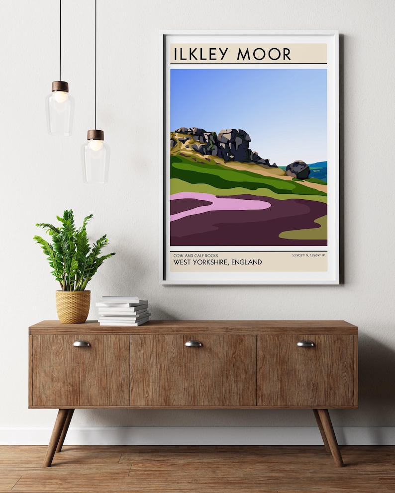 May include: A minimalist poster with a graphic illustration of Cow and Calf Rocks in Ilkley Moor, West Yorkshire, England. The poster has a beige background with black text and a white border.