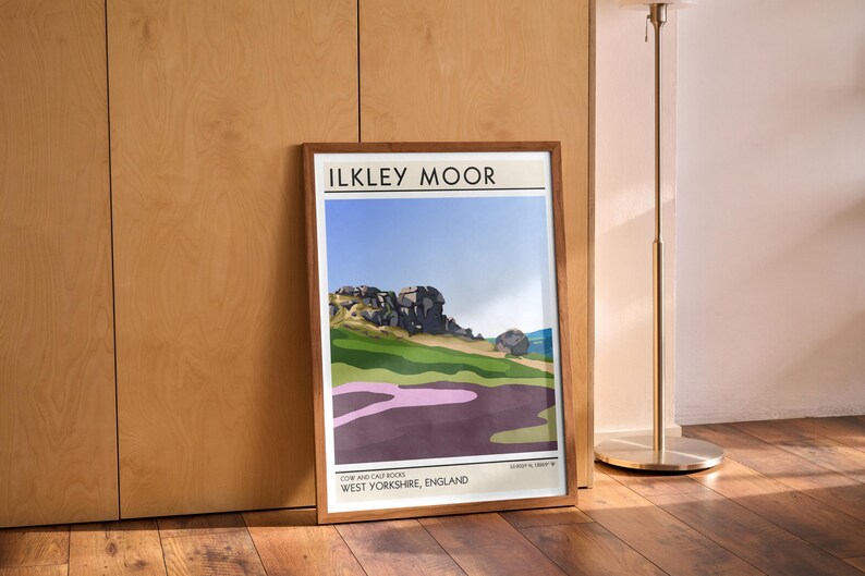 May include: A framed print of a landscape scene with a mountain range in the background. The print is titled "Ilkley Moor" and includes the text "Cow and Calf Rocks, West Yorkshire, England".