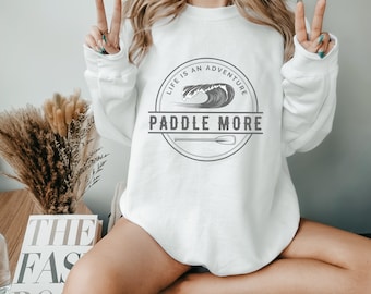 May include: White sweatshirt with a gray graphic that says "Life is an adventure, Paddle More" with a wave and paddle design.