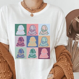 Puede incluir: Camiseta blanca con un dise&ntilde;o de pop art colorido de un rostro de hombre repetido nueve veces.