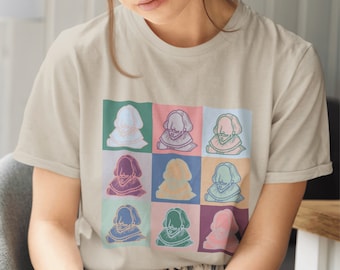 May include: A beige t-shirt with a colorful graphic print of nine different images of a man with a beard. Each image is in a different color and has a different expression.