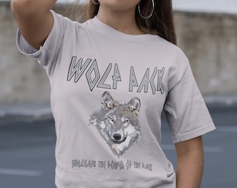 May include: A light gray t-shirt with a wolf graphic and the text "Wolf Pack Unleash the Power of the Pack".