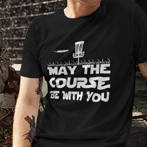 May include: Black t-shirt with a white graphic of a disc golf basket and the text "May the Course Be With You".