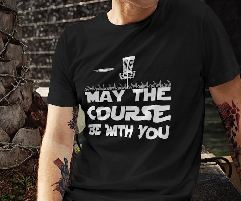 May include: Black t-shirt with a white graphic of a disc golf basket and the text "May the Course Be With You".