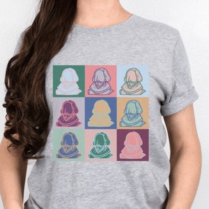 Puede incluir: Una camiseta gris con un dise&ntilde;o de pop art colorido que presenta una imagen repetida de un hombre con barba y un cuello de encaje.