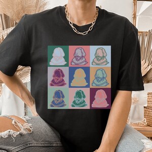 Puede incluir: Una camiseta negra con un gr&aacute;fico colorido de la cara de un hombre repetido nueve veces en una cuadr&iacute;cula.