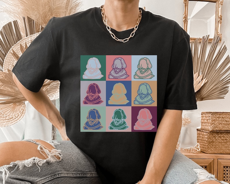 Puede incluir: Una camiseta negra con un gr&aacute;fico colorido de la cara de un hombre repetido nueve veces en una cuadr&iacute;cula.