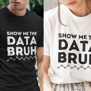 May include: Two t-shirts with the text "Show me the data bruh" in white letters on a black and white background. The text is in a bold, playful font. A line of small circles and lines is below the text.