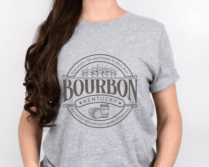 May include: Gray t-shirt with a brown graphic of a circle with the text "TOO MUCH OF ANYTHING IS BAD, BUT TOO MUCH BOURBON IS BARELY ENOUGH" and the word "BOURBON" in a large font with the text "KENTUCKY" underneath.