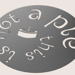 Può includere: Un cerchio di metallo grigio con le parole "Non è una torta?" e "Questa è una torta" scritte in un carattere decorativo. Un'immagine stilizzata di una torta con una candela in cima è al centro del cerchio.