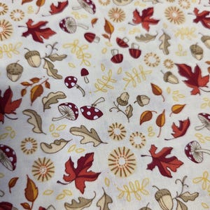May include: A white fabric with a repeating pattern of red and brown leaves, acorns, mushrooms, and stylised flowers.