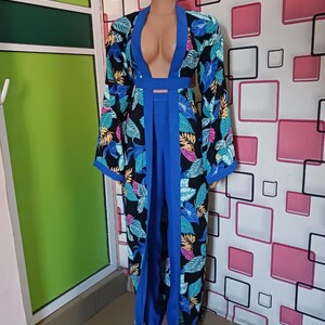 Può includere: Una lunga veste con stampa floreale nera e blu con scollo profondo e maniche lunghe. La veste è cinata in vita e ha uno spacco sul davanti.