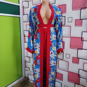 Può includere: Una lunga veste con stampa floreale blu e rossa con scollo a V profondo e un paio di pantaloni abbinati.